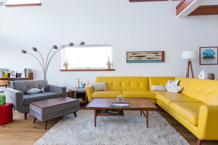 geltona sofa su odiniais apmušalais interjere