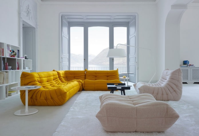 šviesiai geltona sofa interjere
